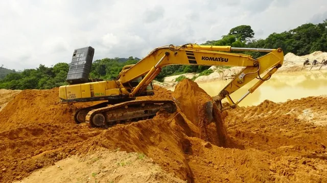 Excavator working on a riverbank earthworks project